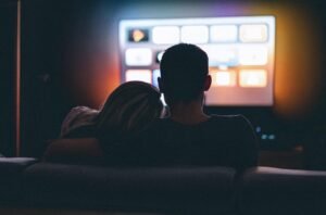 Personne consultant un programme IPTV sur tablette dans le salon”